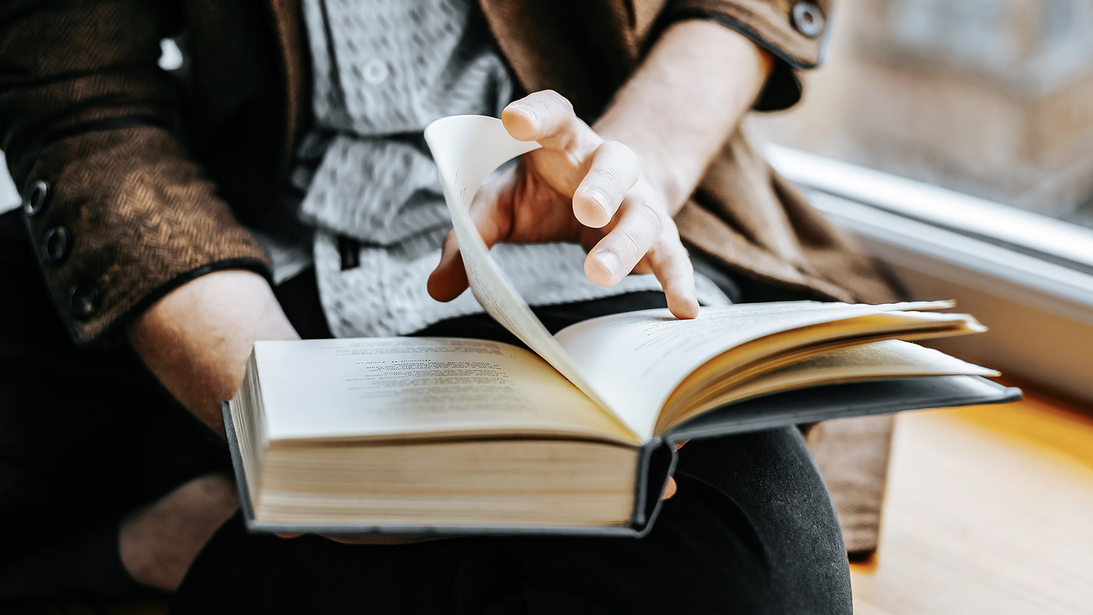 Close up hand of a man flipping pages of book