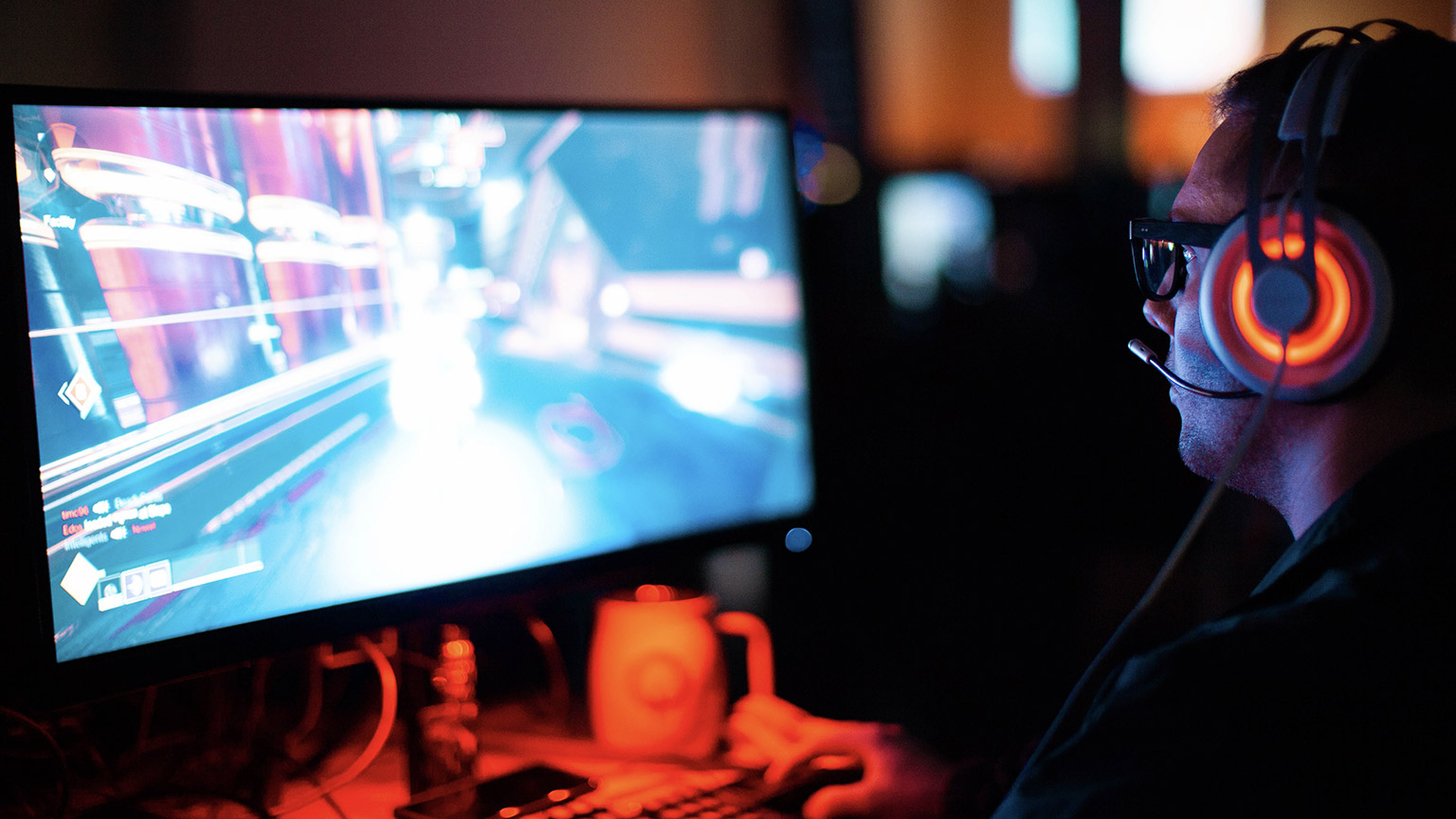 A gamer working on a laptop at a table