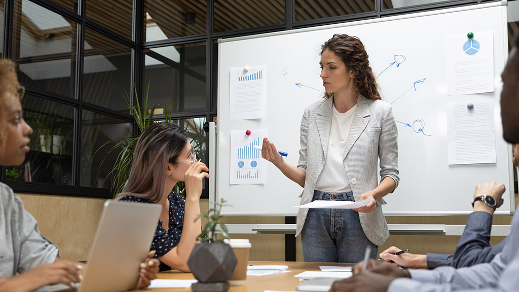 employees listening to confident team leader, explaining project details