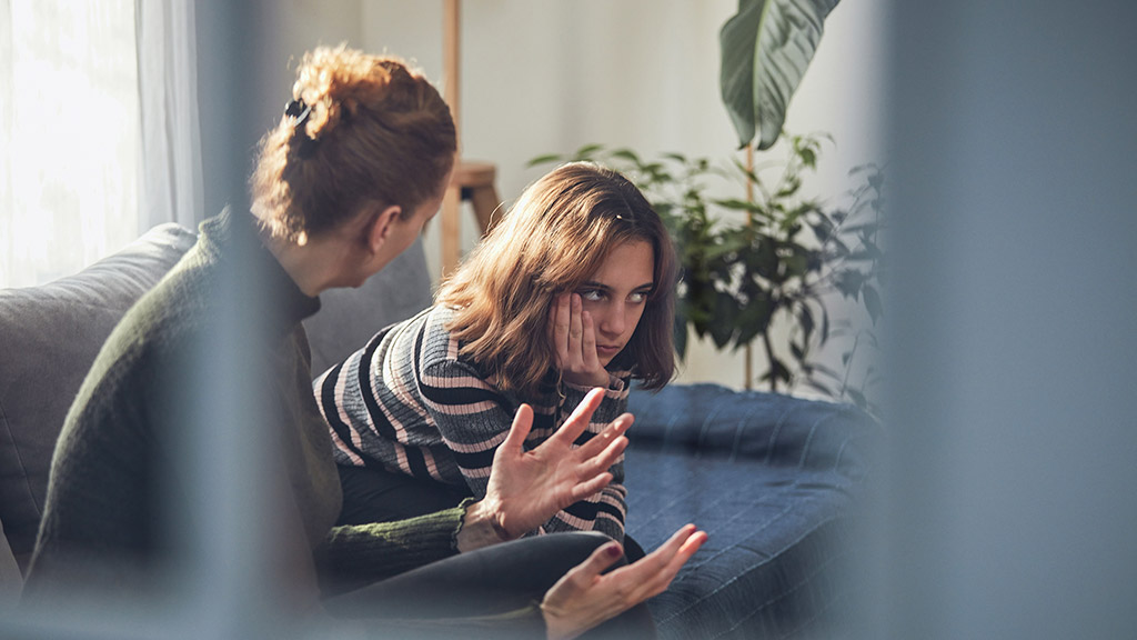 Teenage girl in difficult mood being scolded by her mom