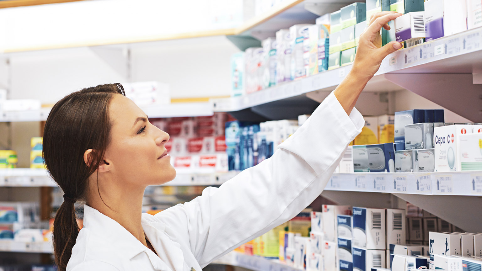 A pharmacist taking medication off a shelf