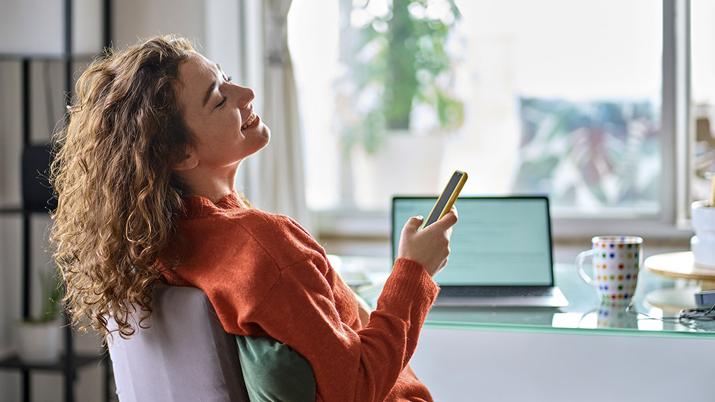 woman holding smartphone using cell mobile phone taking break relaxing while remote working