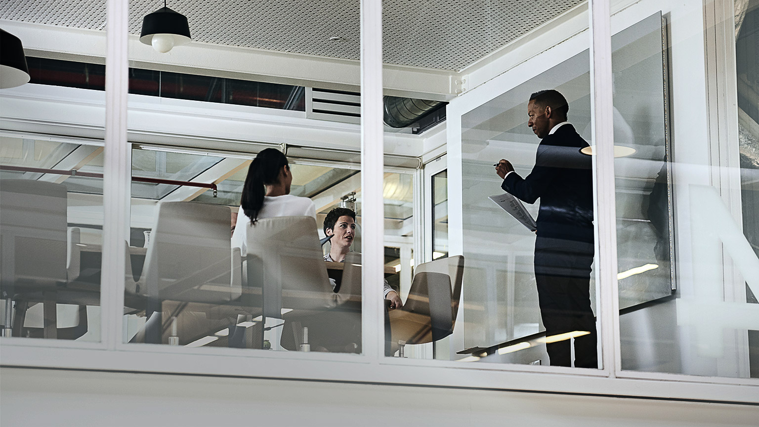 A person giving a presentation to coworkers on a white board in a meeting room