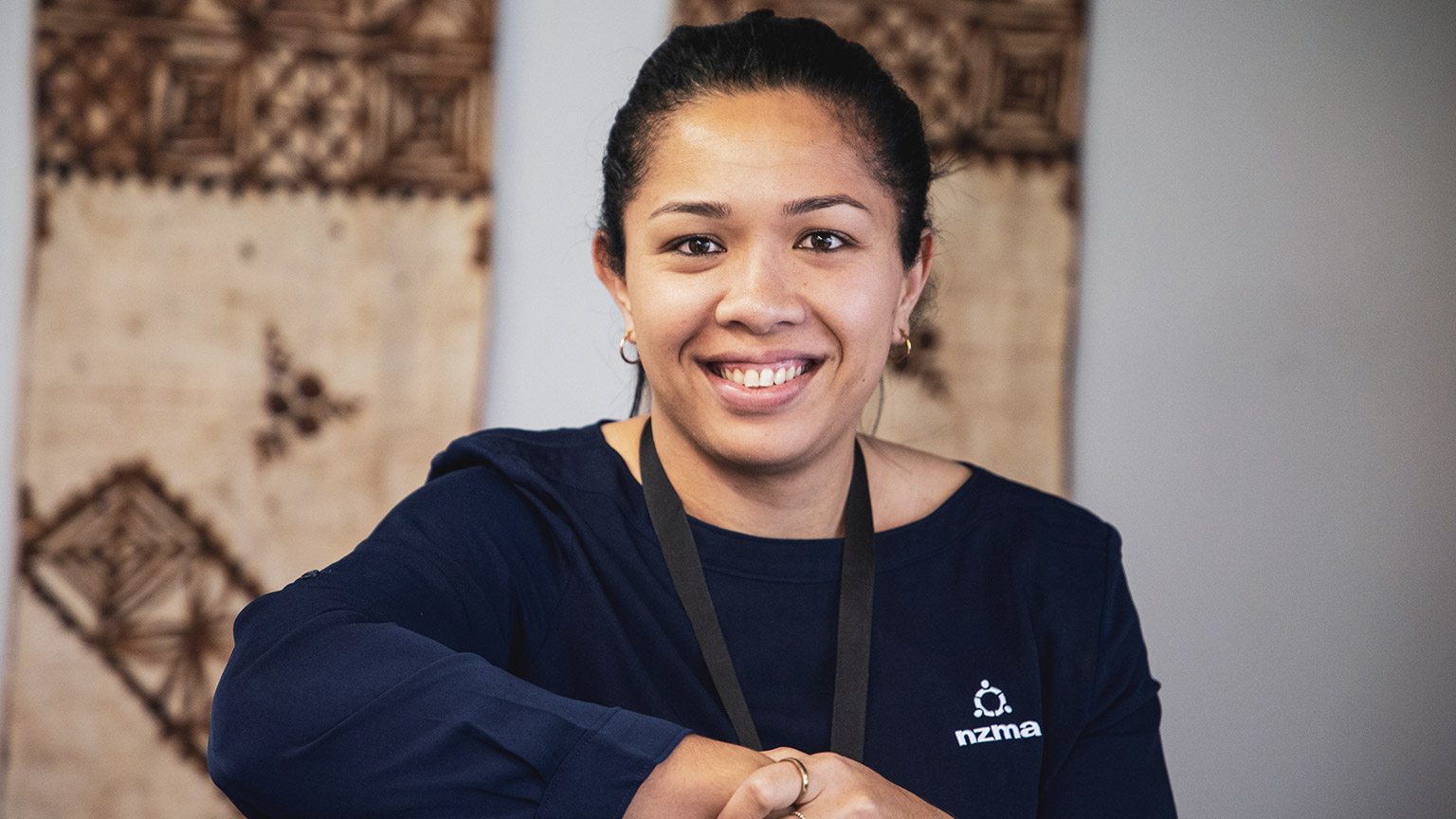 A person smiling at the camera in an office environment