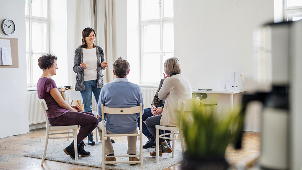 A woman talking to other people during group therapy