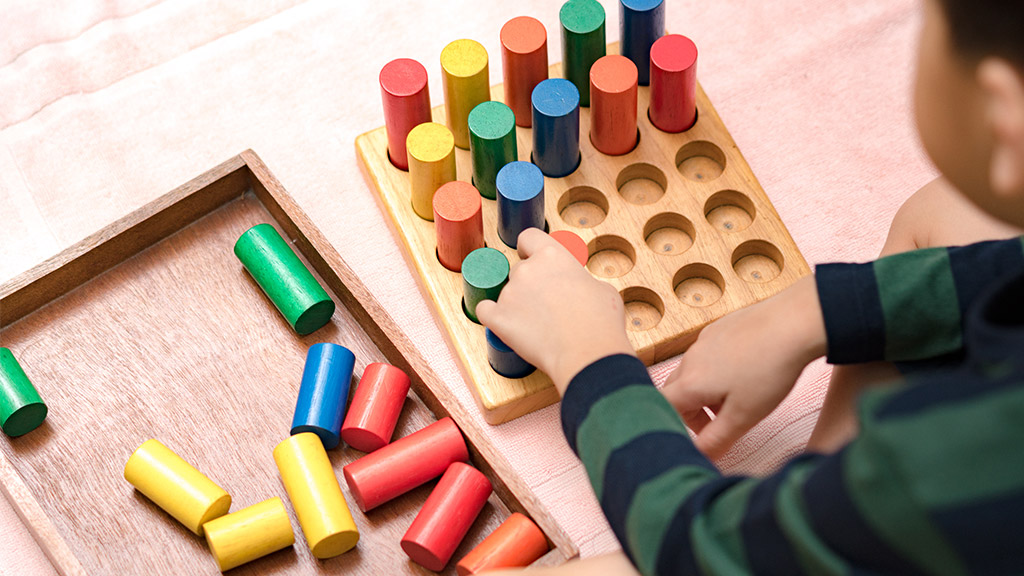 Hands of a little Montessori kid (3-6) learning about size