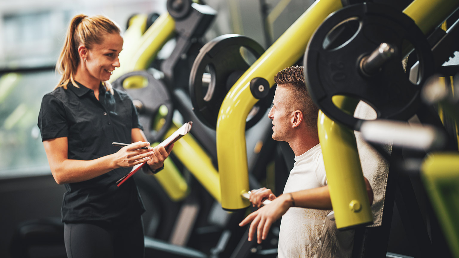 A trainer with a client in a modern gym