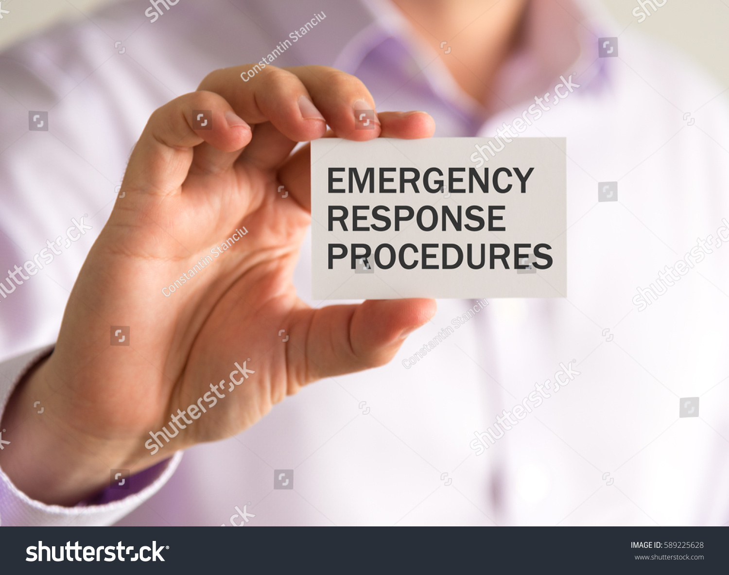 Closeup on businessman holding a card with ERP EMERGENCY RESPONSE PROCEDURES message