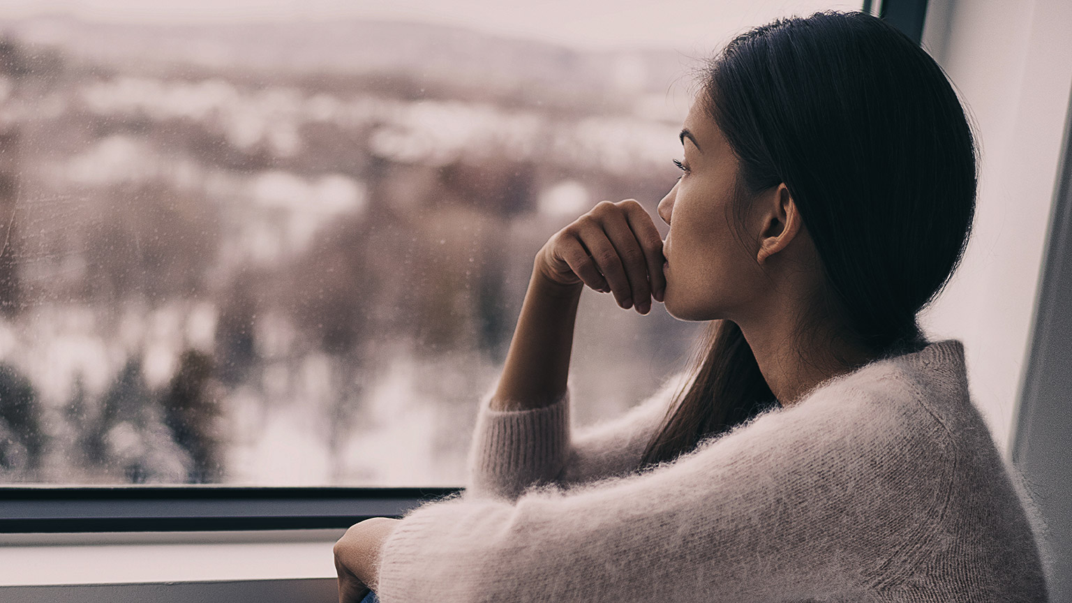 Sad pensive woman at home Winter depression - seasonal affective disorder mental health looking out the window alone. Self isolation