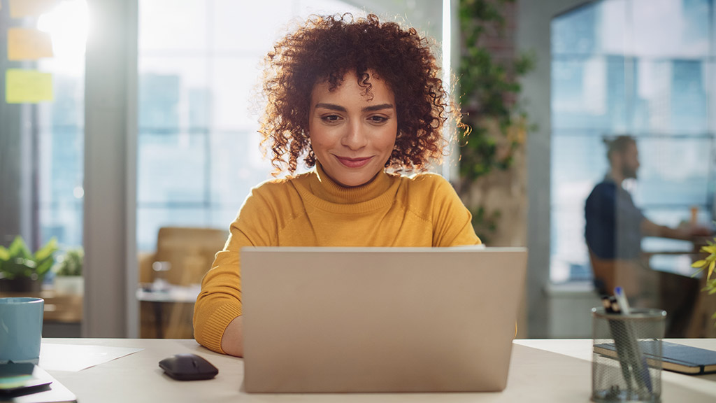 Beautiful Middle Eastern Manager Sitting at a Desk in Creative Office