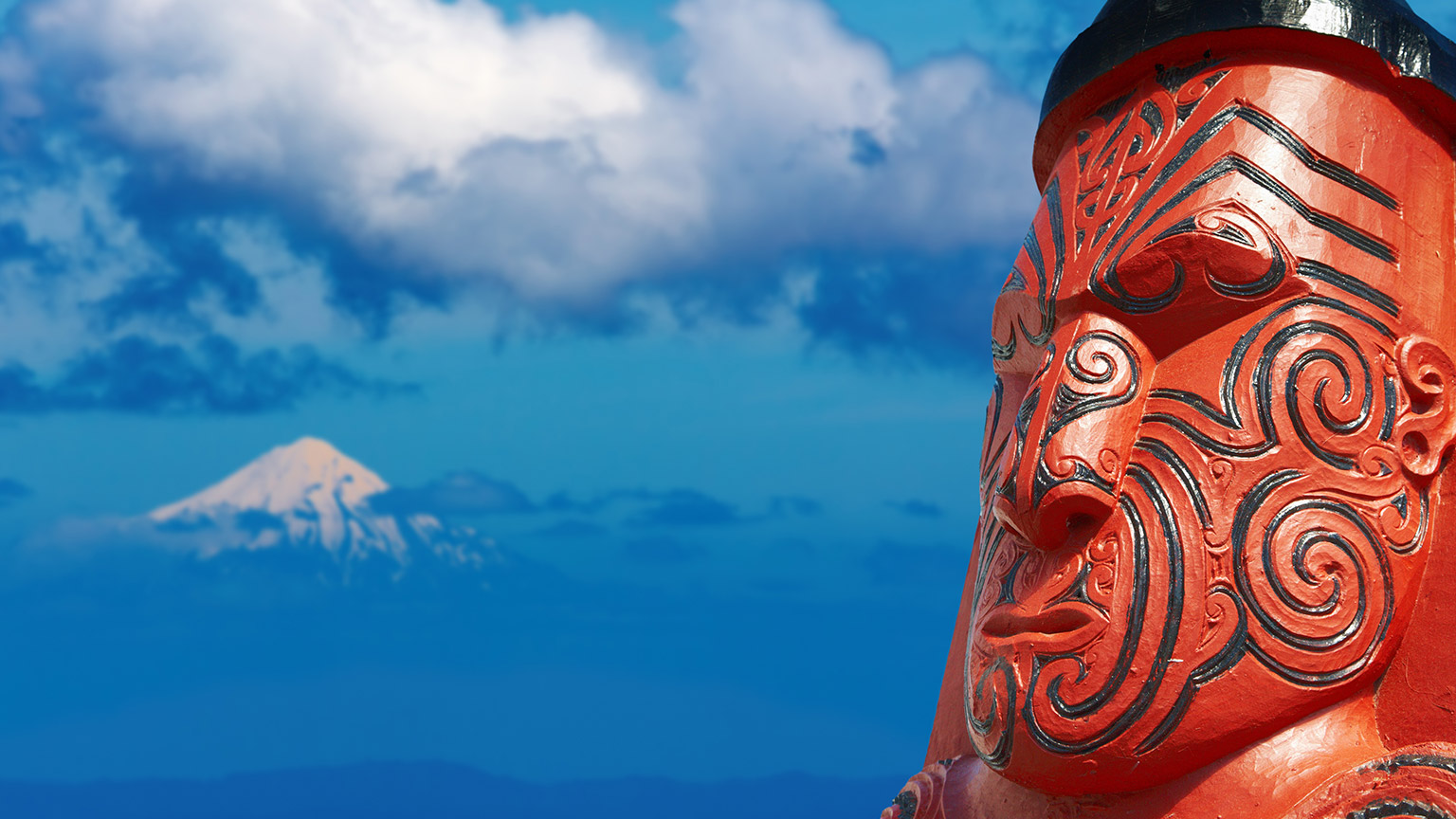 Traditional maori carving over Taranaki Mount background, New Zealand