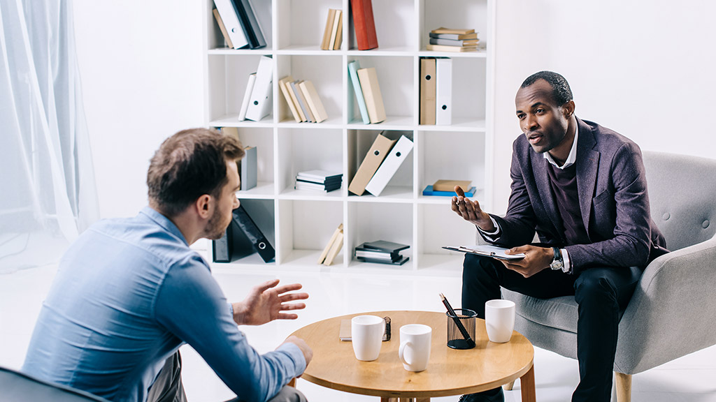 African american psychiatrist talking to young male client