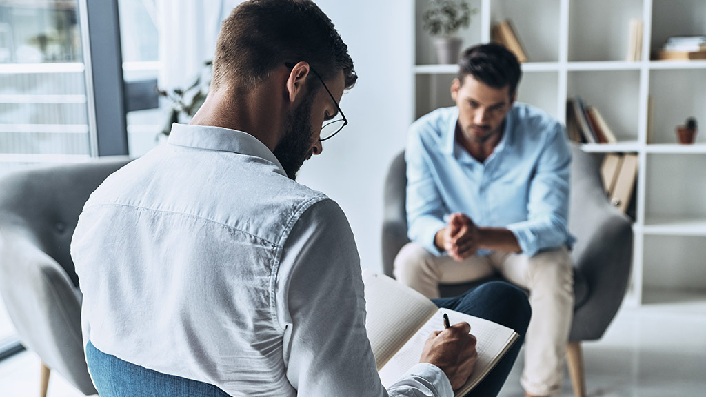 man sharing his problems while having therapy session with psychologist