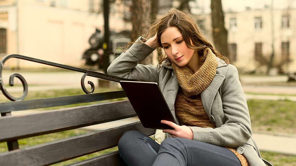  Young woman sitting with Tablet and reading