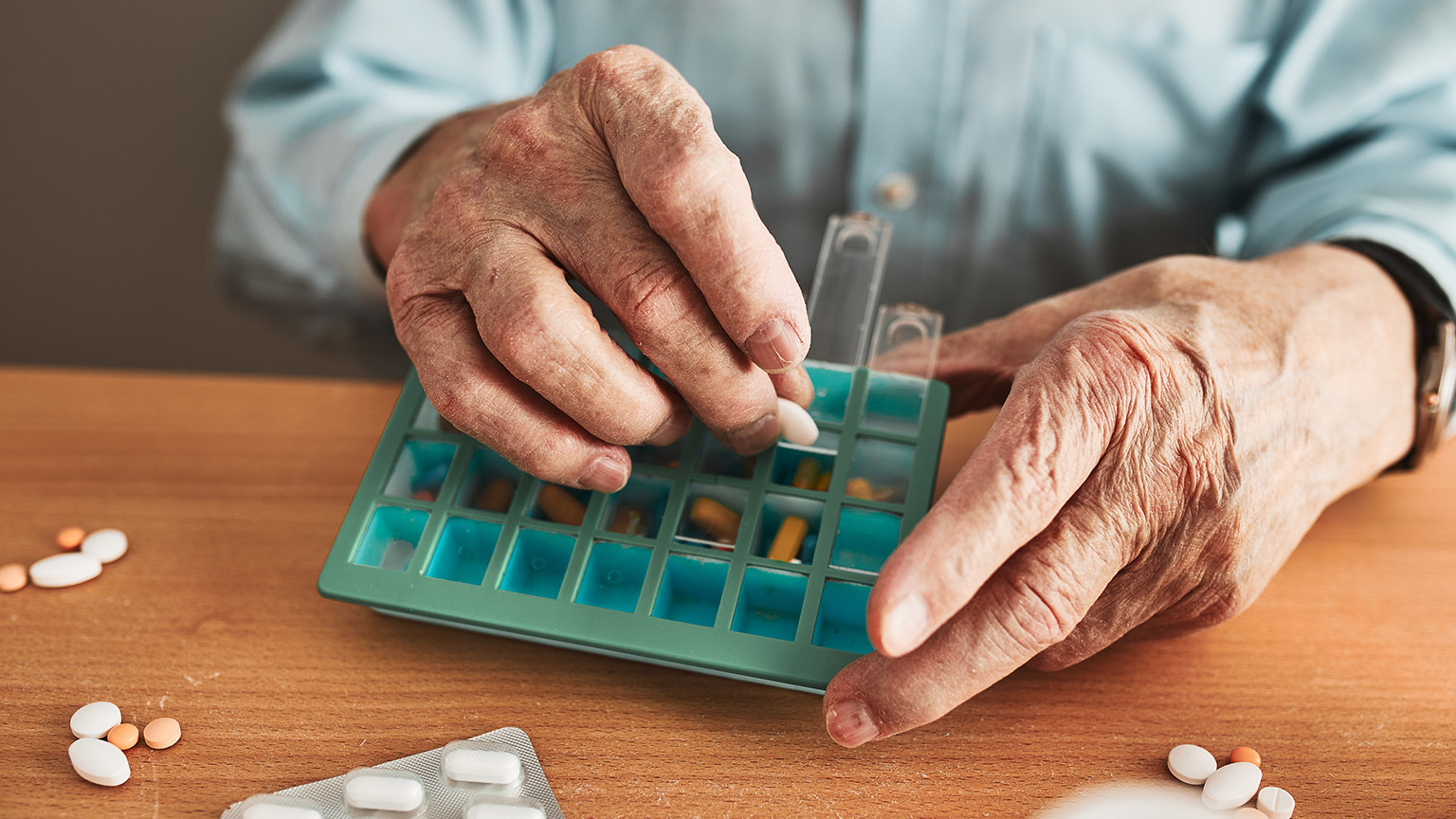 A close view of an elderly person sorting medication