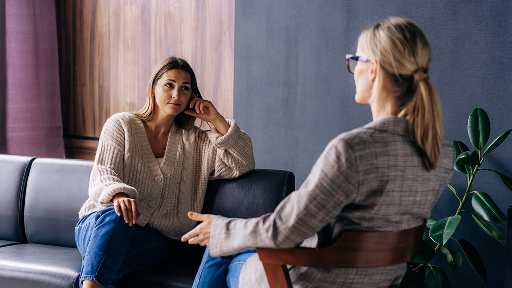 A young woman in a consultation with a professional psychologist listens to advice