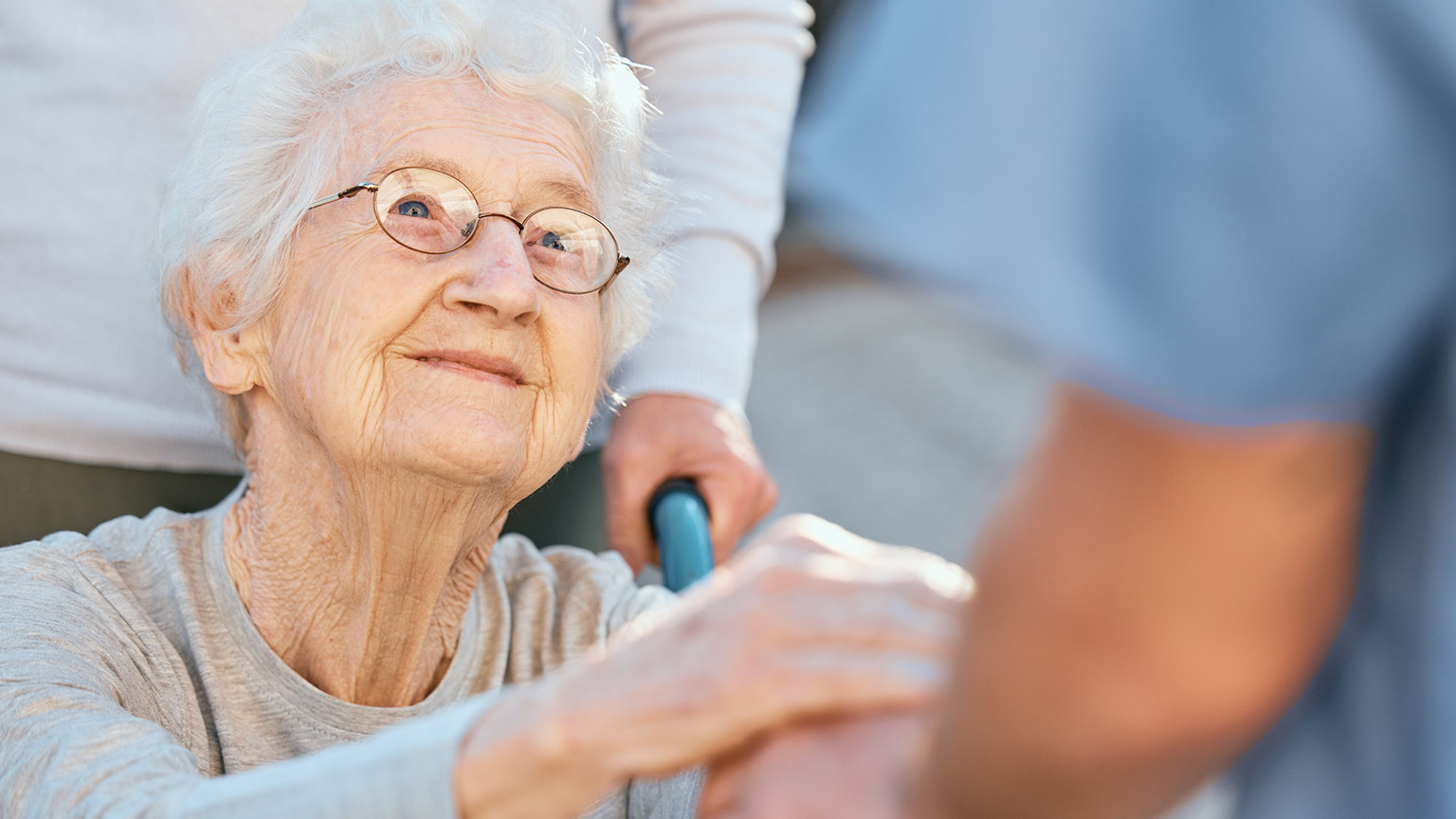 An elderly patient looking up at a carer