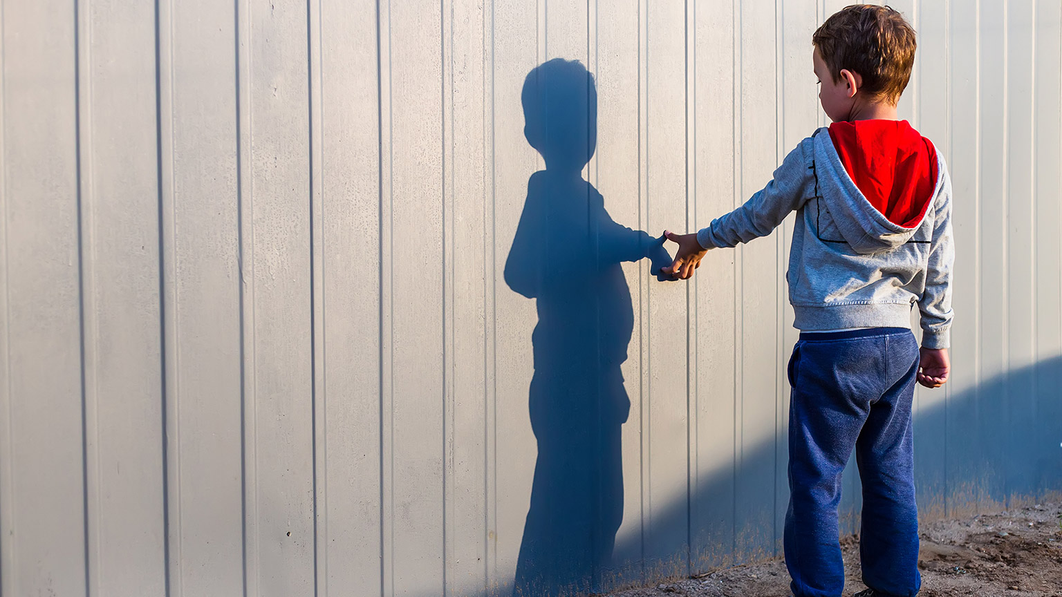 A young autistic child standing by themselves