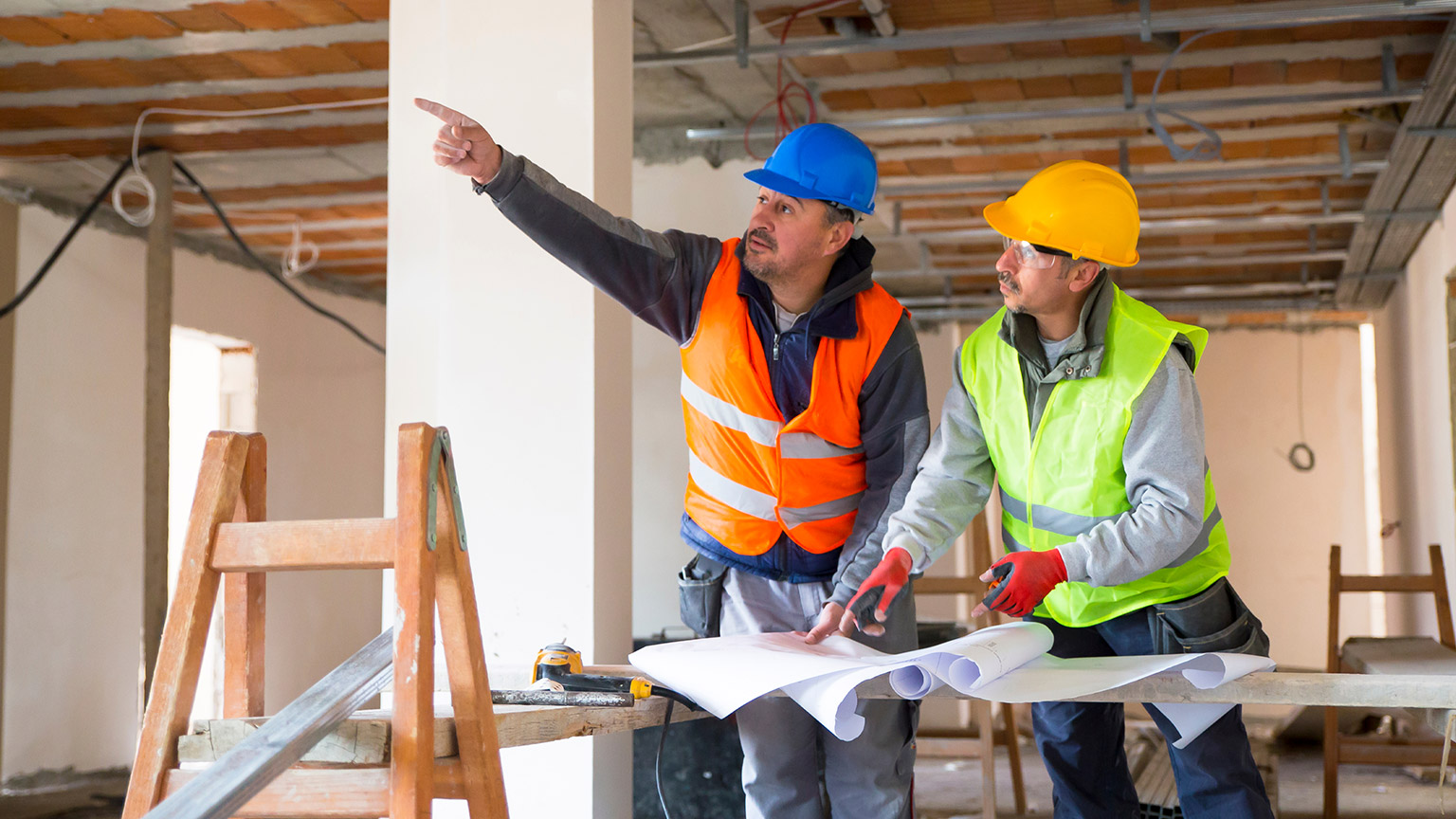 A foreman pointing something out to a tradesman