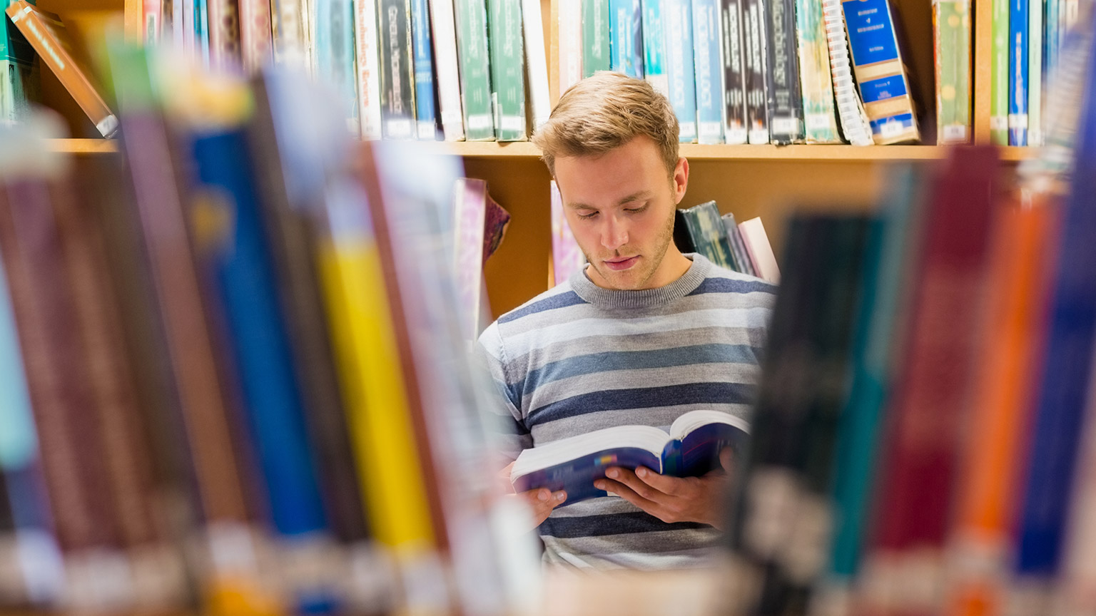 A person reading a book in a library