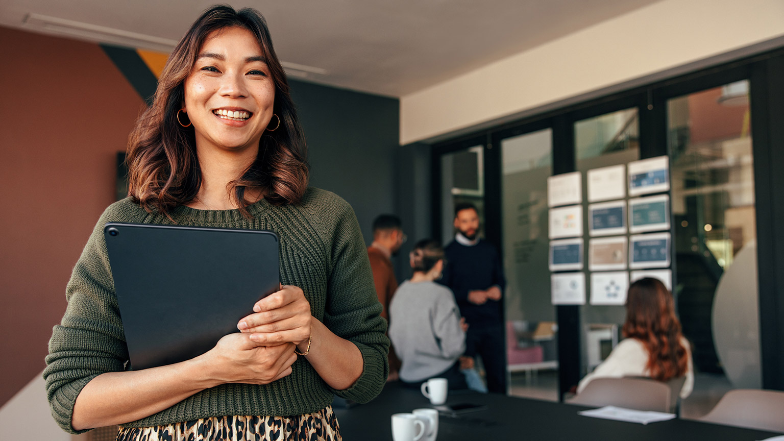 A person smiling at the camera in a modern office