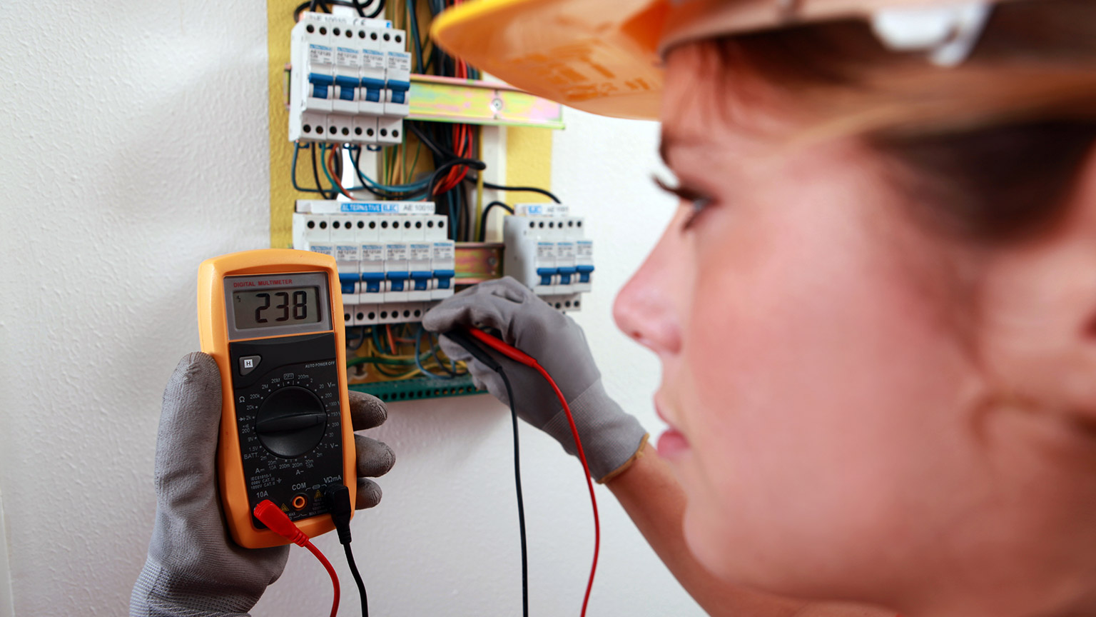 An electrician using a multimeter