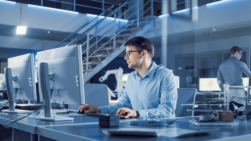 a man working on his desktop PC in a office