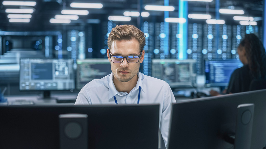 man working at data center using computer