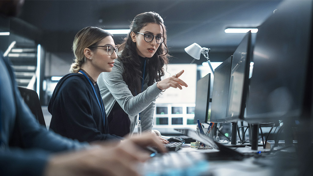 a man and two women working in cyber security software development departmen