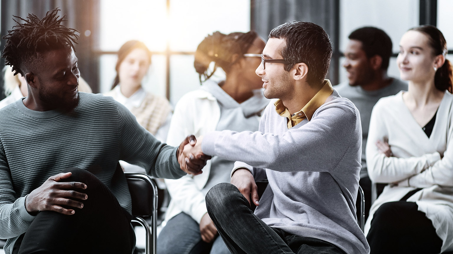 Men shakes hands while in a meeting