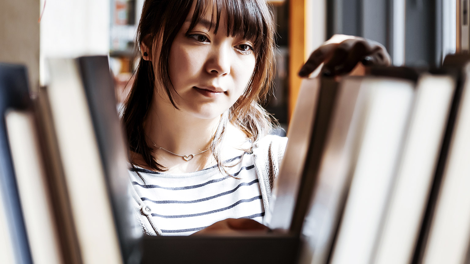 Young woman sorting books in the library