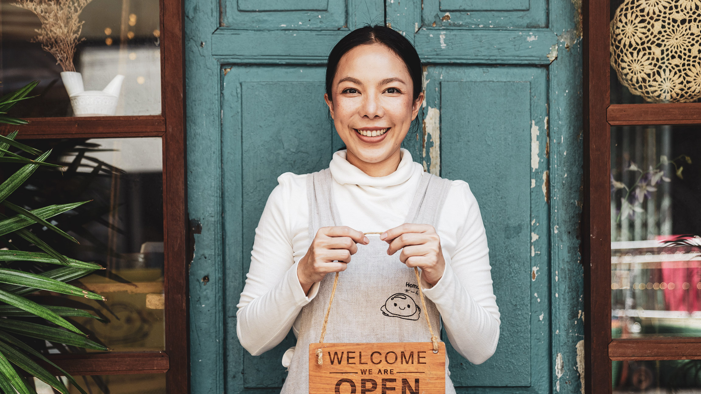 A small business owner standing outside their business