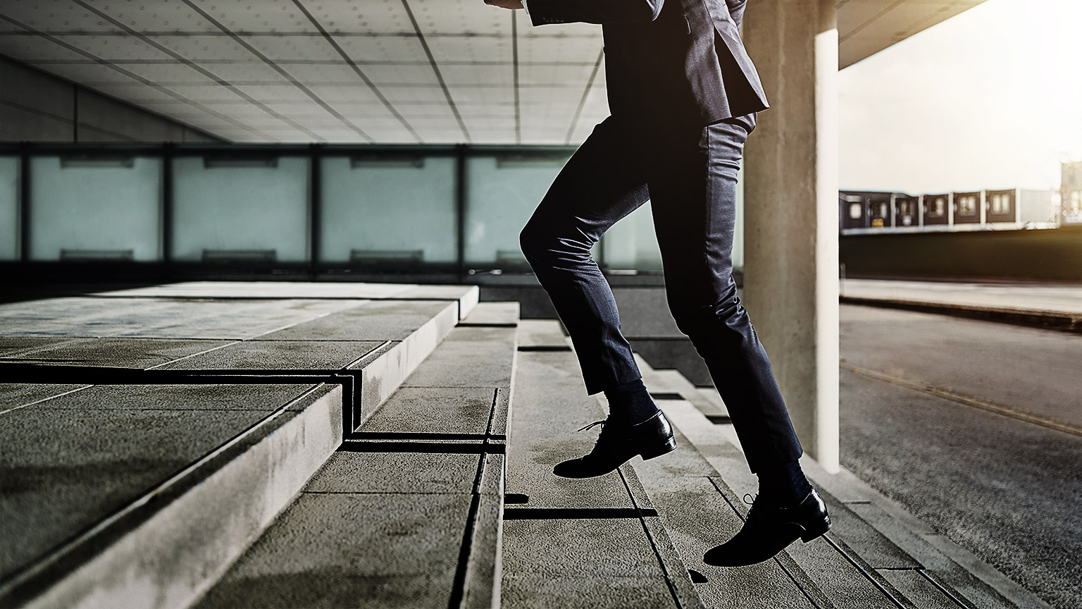 Businessman running fast upstairs. Horizontal outdoors shot.