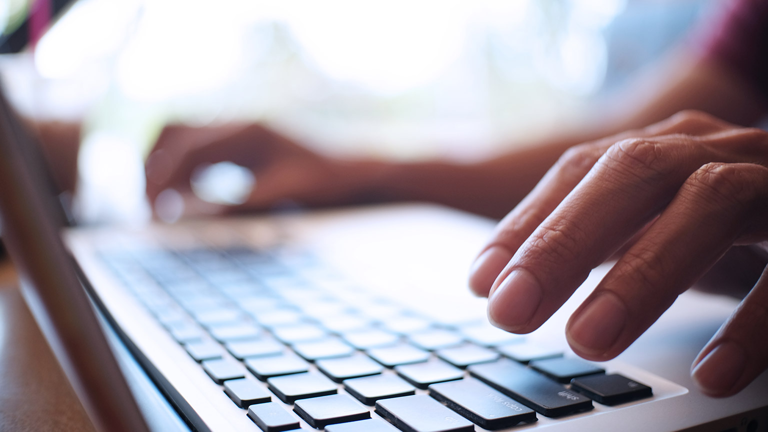 A close view of a person typing on a laptop