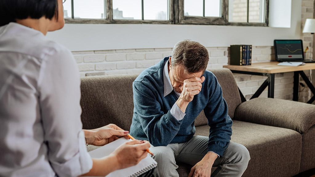 Having an appointment. Despaired short-haired patient having mental issues and explaining them to experienced psychotherapist