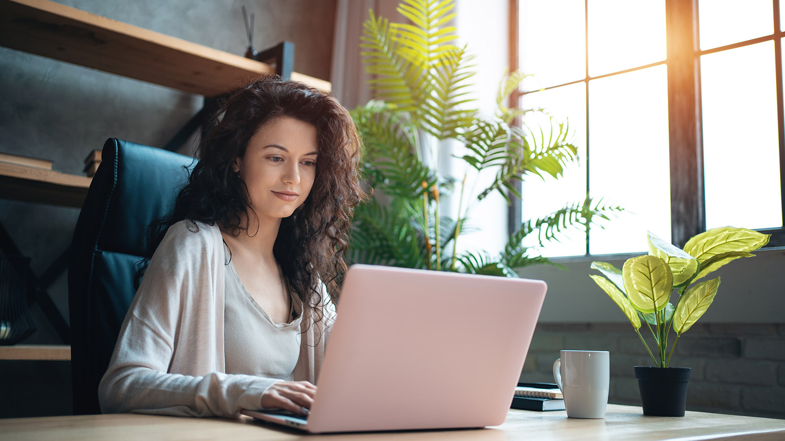 A woman using her laptop at an informal desk