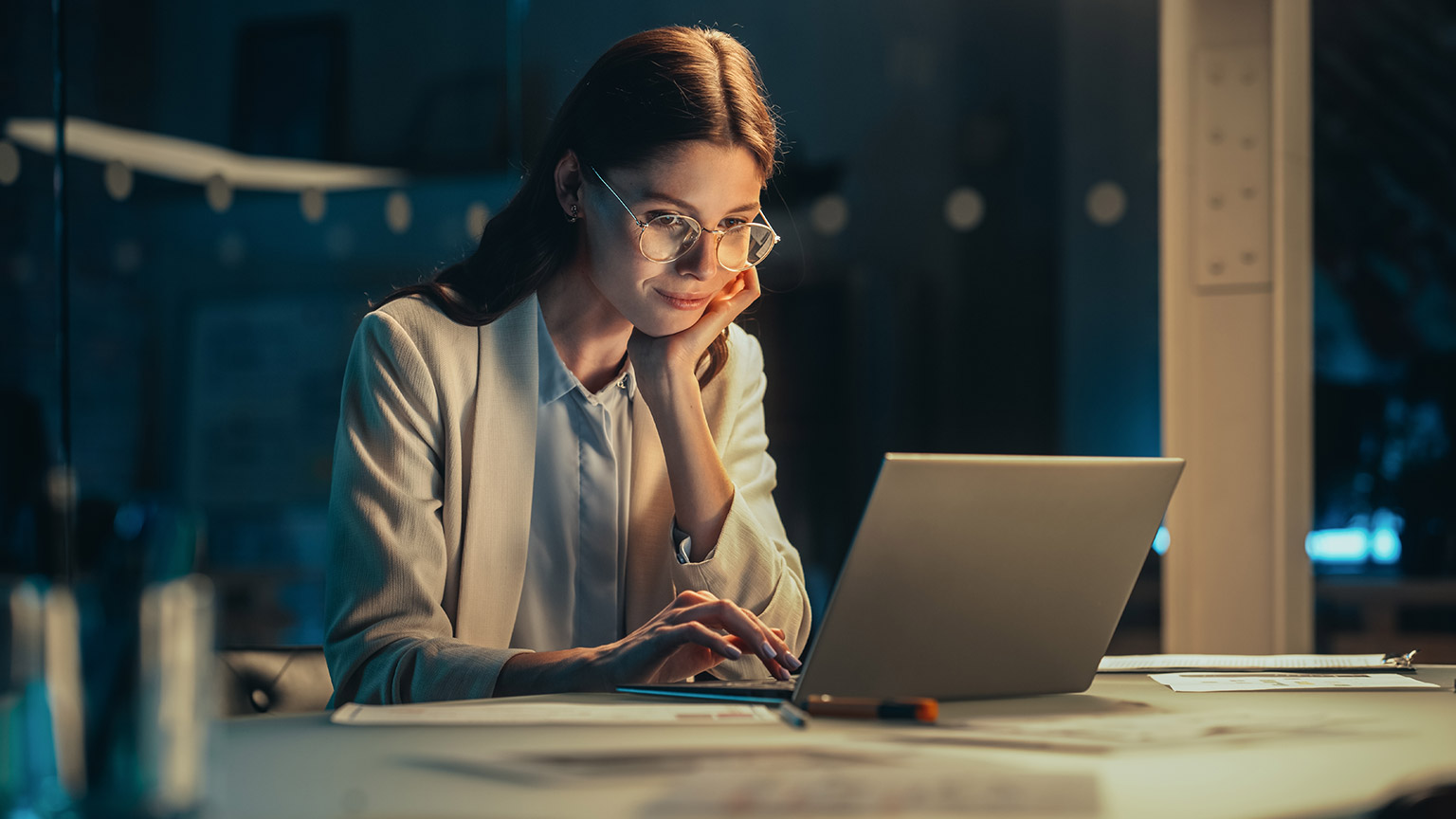 A person reading information on a laptop in an office