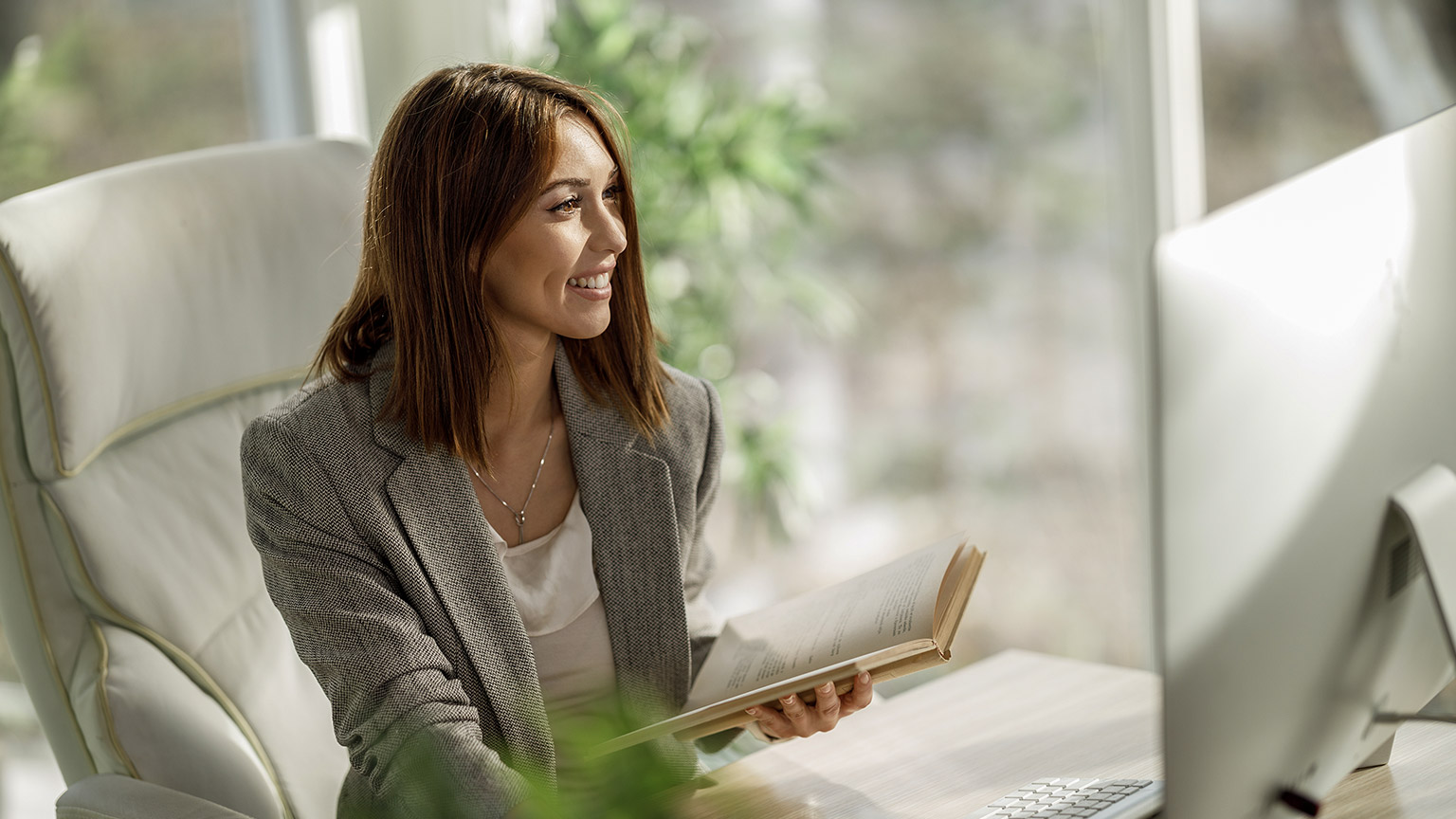 An attractive business woman sitting alone in her home office and working on computer