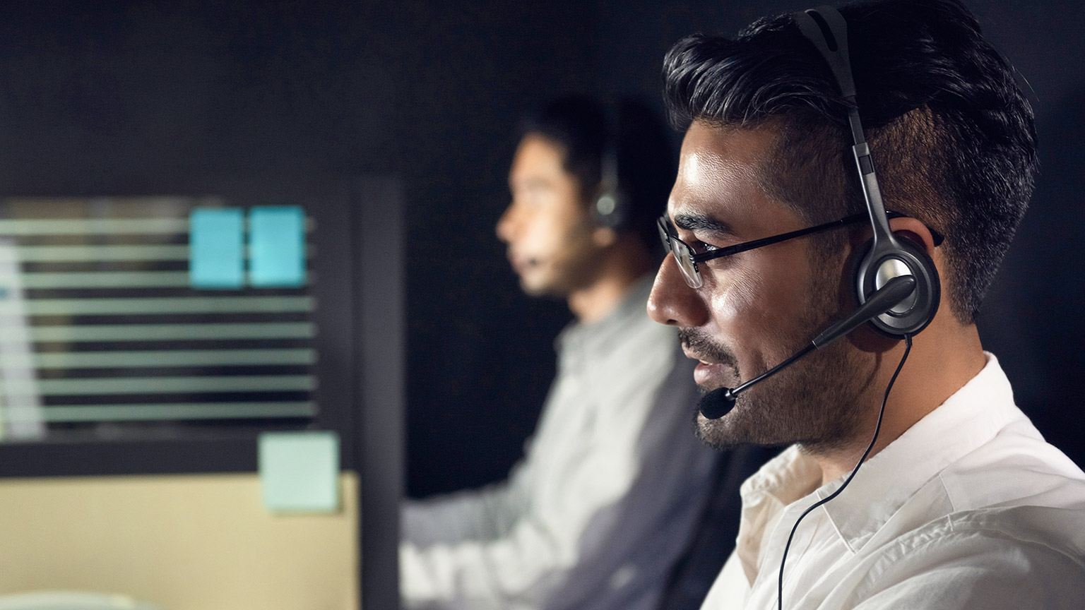 Asian business man working night shift in call center office with colleague