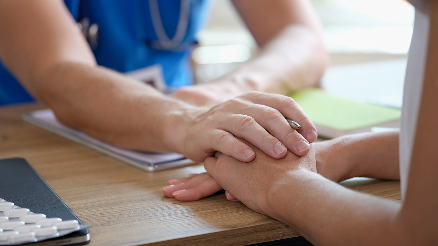 Psychologist or gynecologist holds hands of a female patient and provides professional psychological assistance closeup, 