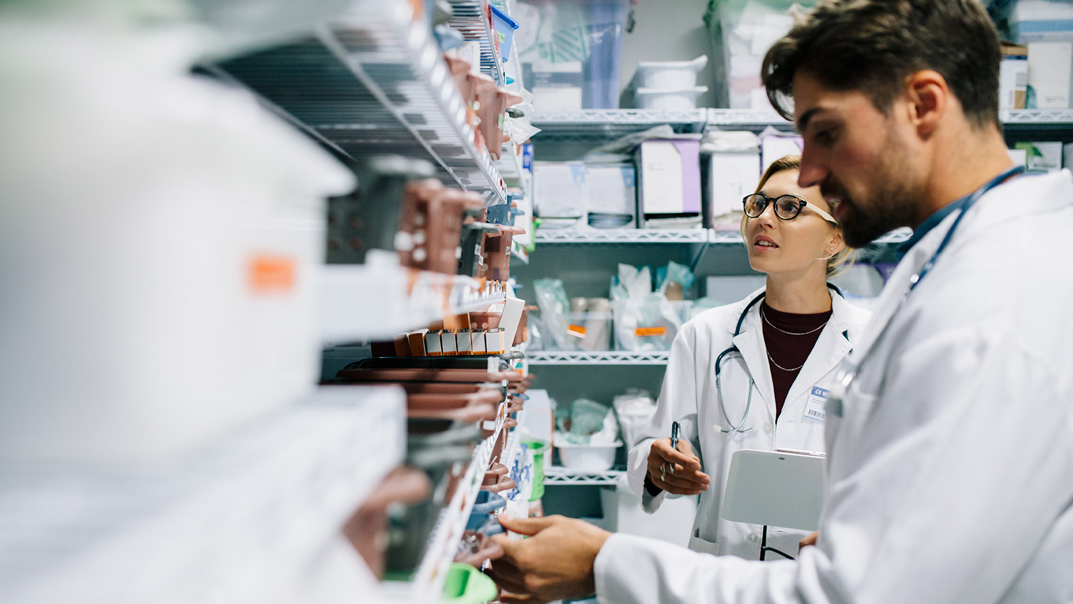 Pharmacists looking at medicine on a shelf