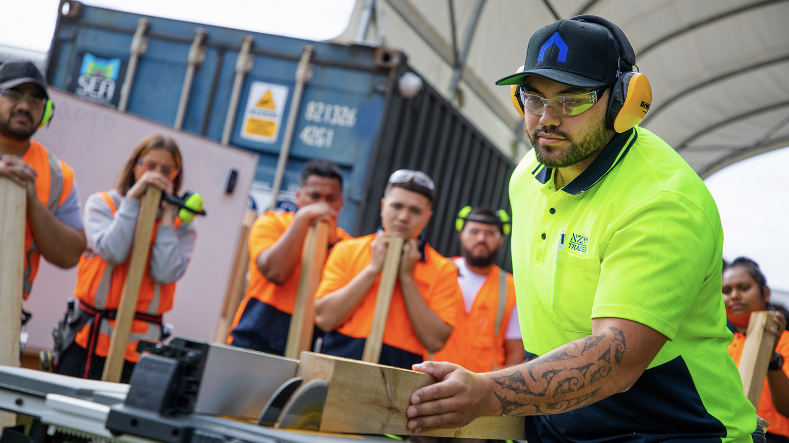 A tradesman demonstrating something to apprentices