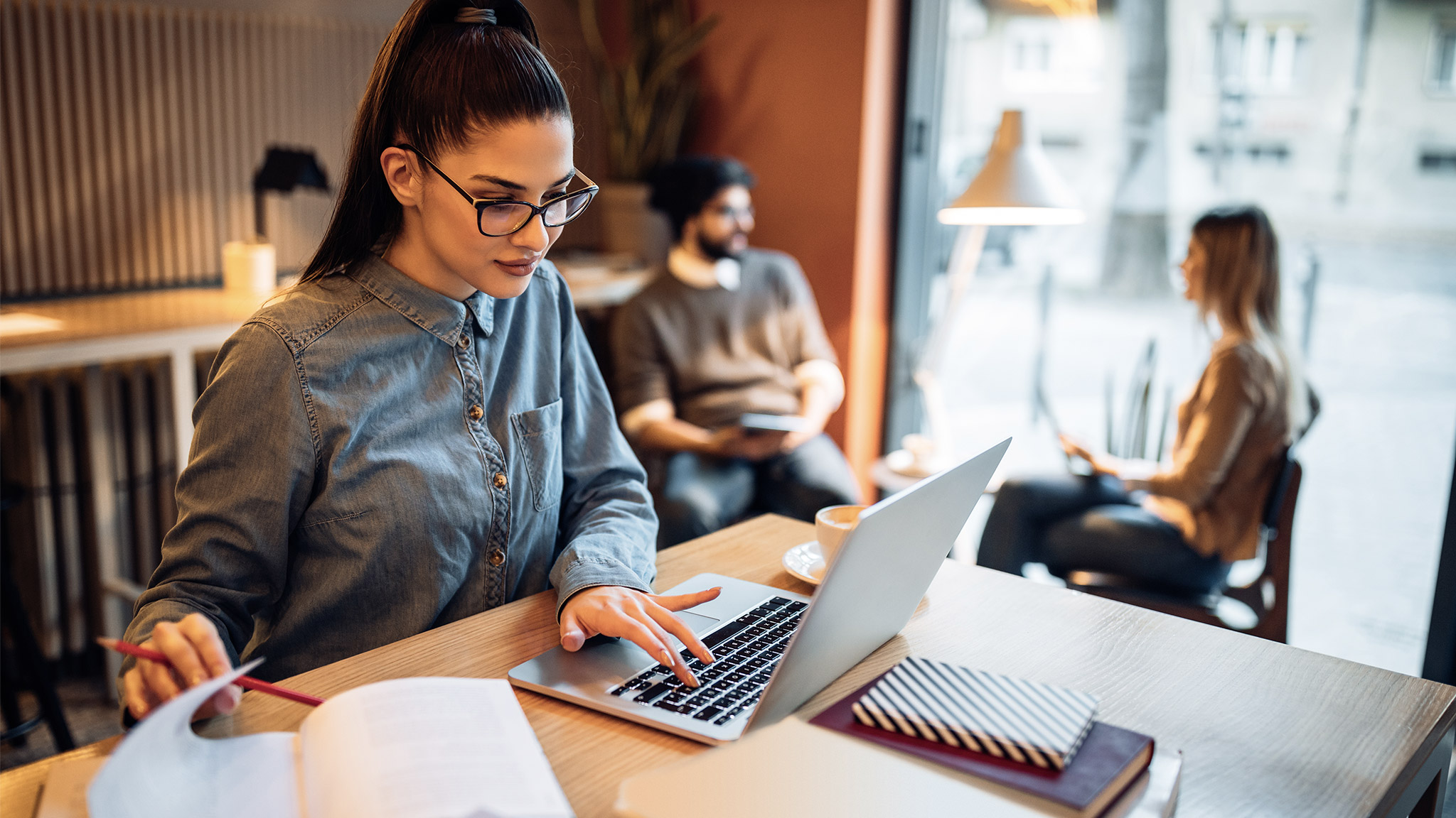 Young female student sitting in front of her laptop computer in a coffee shop