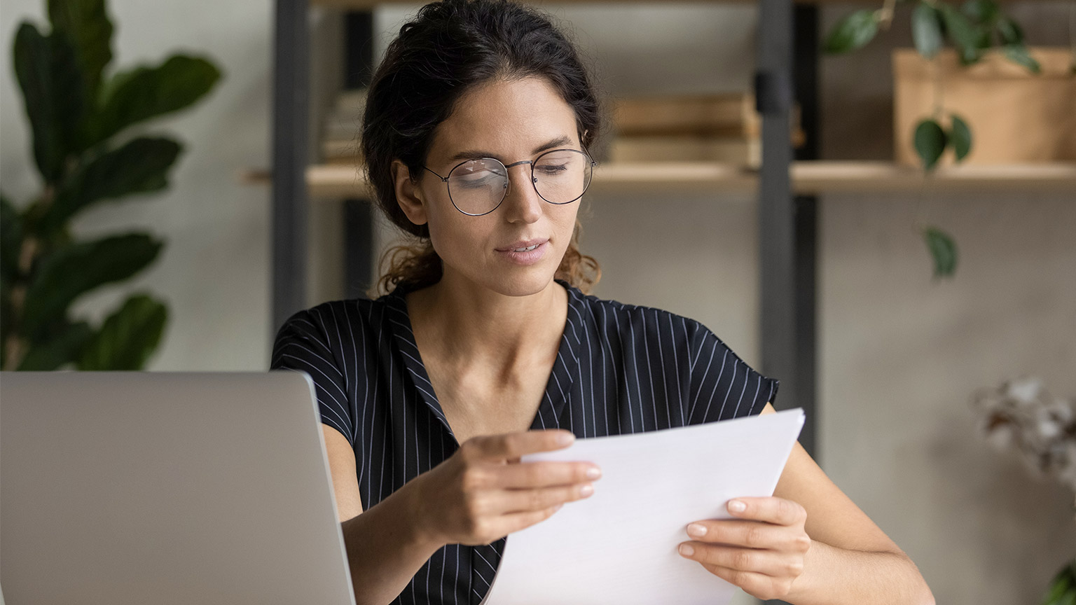 Important papers. Serious hispanic female manager in glasses engaged in office paperwork study project documentation cover letter.