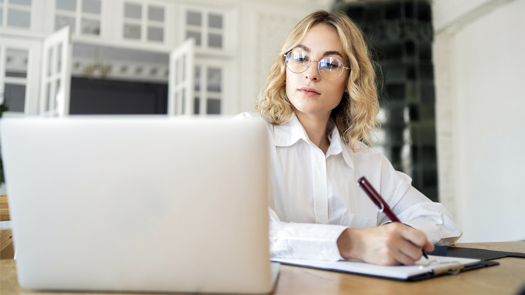 Female manager working in office online report using laptop