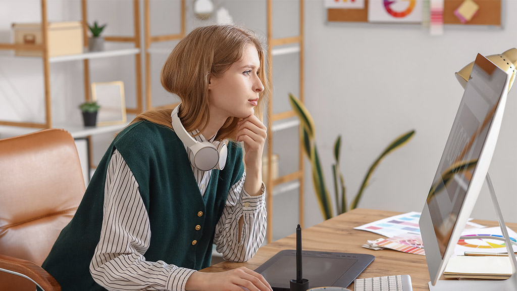 Female graphic designer working with computer at table in office