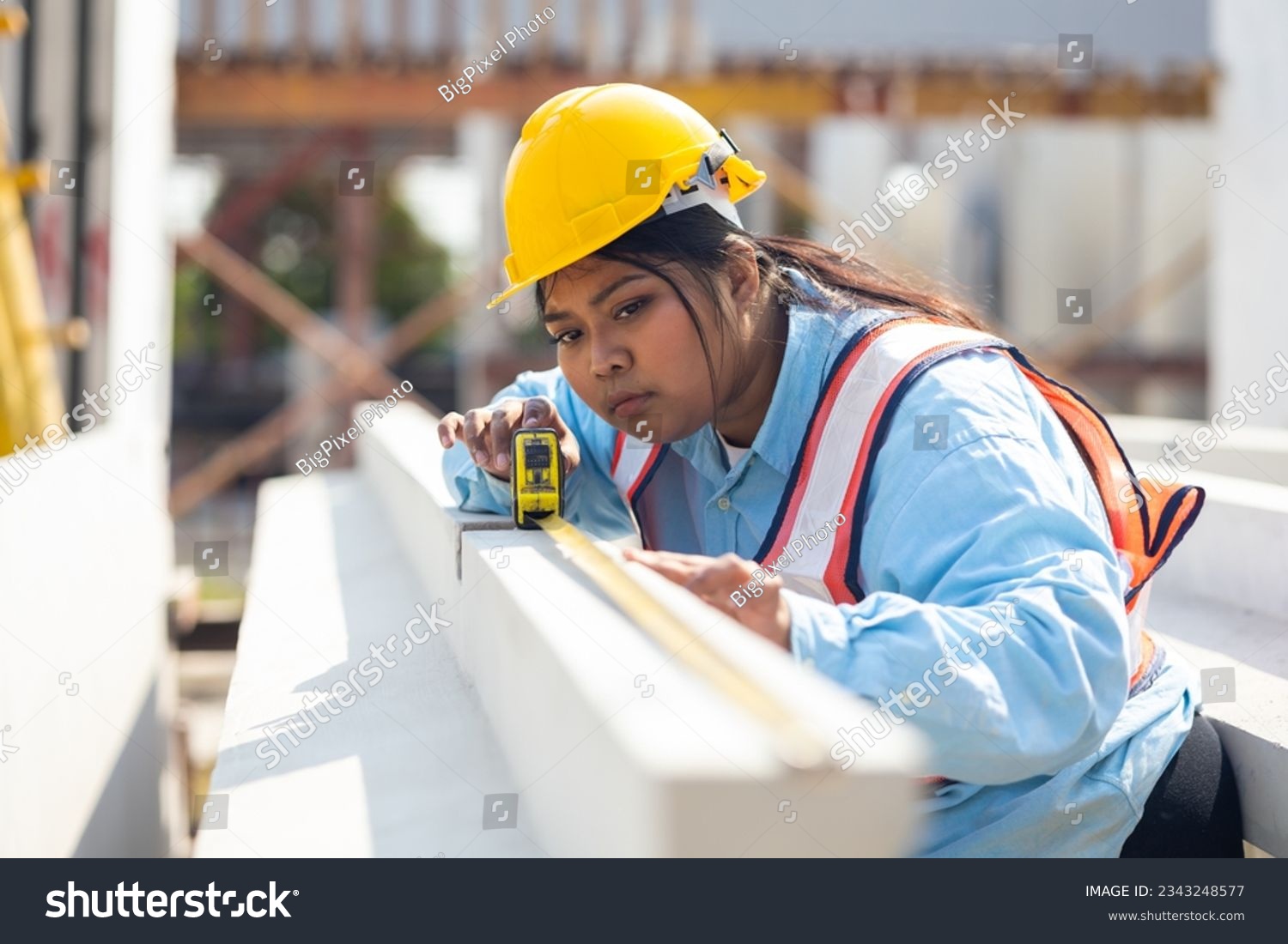A woman measuring at a construction project.