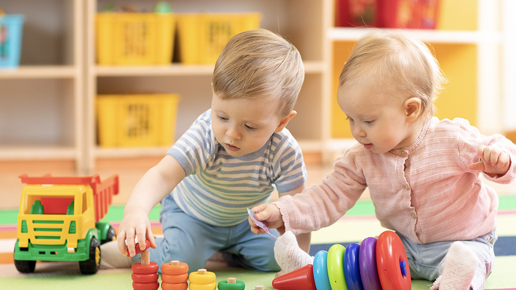 Preschool boy and girl playing on floor with educational toys