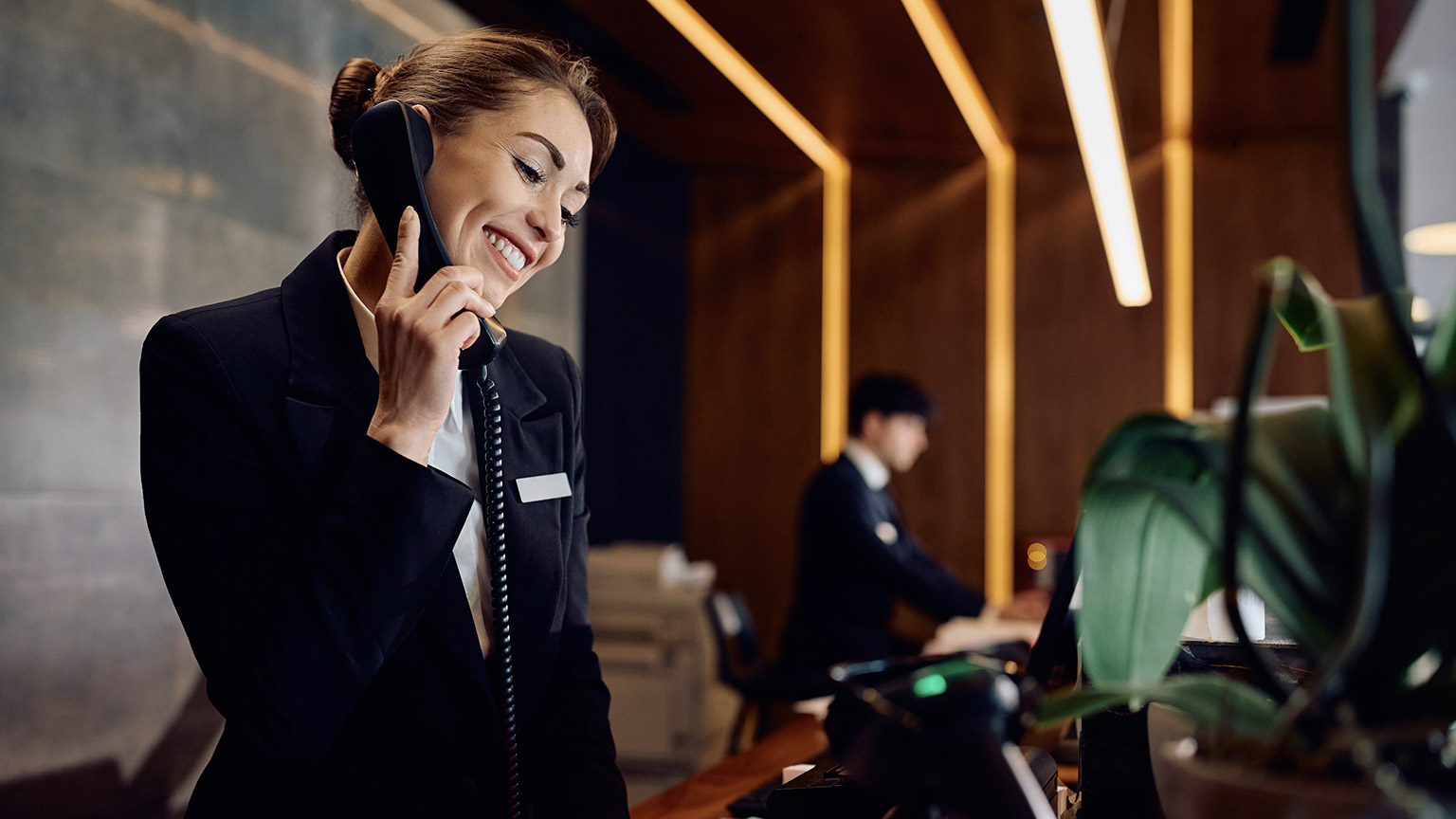 A receptionist talking on a phone in a modern office space