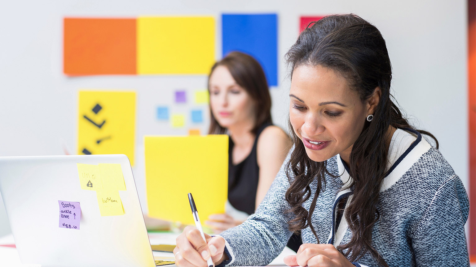 Businesswoman taking notes at desk